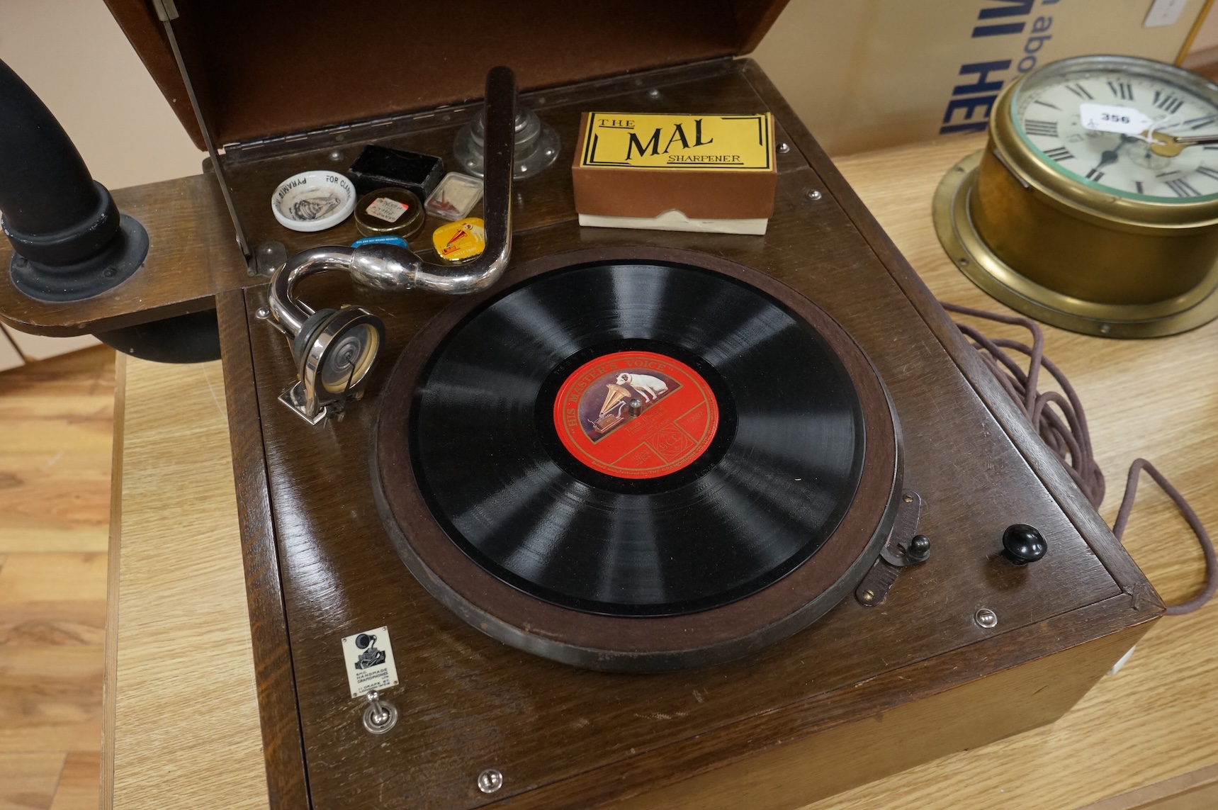 An EMG ‘Handmade Gramophone’ with electrically powered motor, in an oak veneered case with large papier-mâché horn, dimensions of the case; 44 x 53 x 27cm, diameter of the horn 56cm.